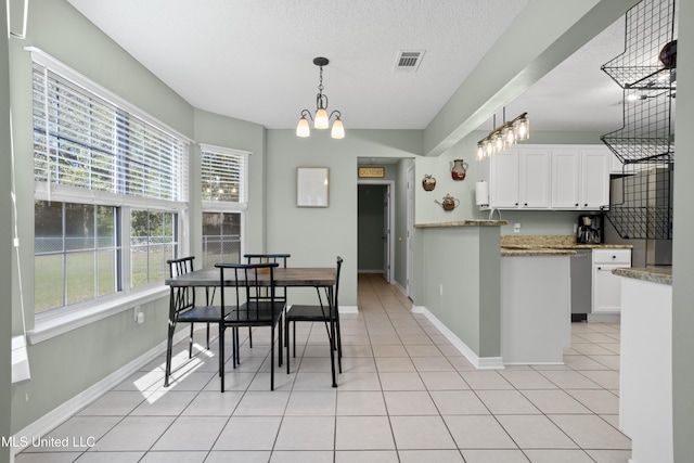 dining space featuring an inviting chandelier, light tile patterned floors, and a textured ceiling