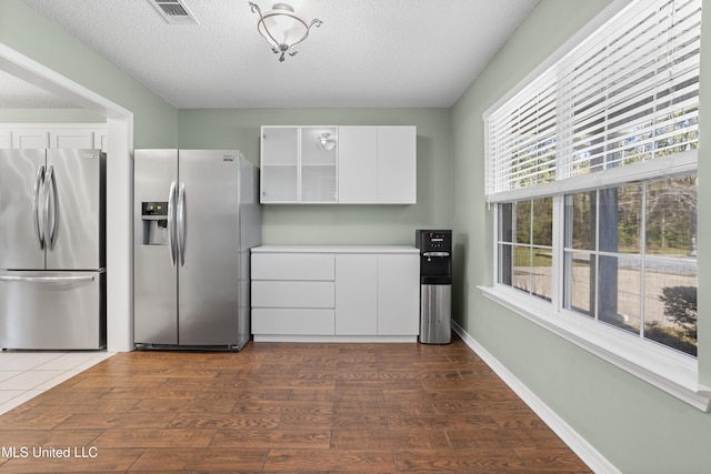 kitchen with stainless steel refrigerator with ice dispenser, white cabinetry, stainless steel refrigerator, and dark hardwood / wood-style floors