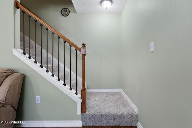 staircase featuring a textured ceiling