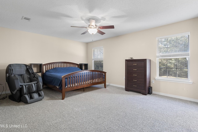 carpeted bedroom featuring a textured ceiling and ceiling fan