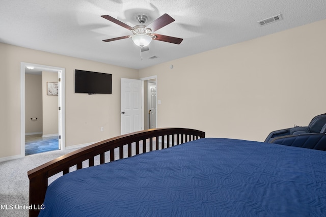 bedroom with a textured ceiling, ceiling fan, and carpet