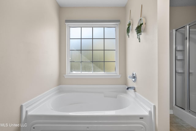 bathroom featuring tile patterned flooring and shower with separate bathtub