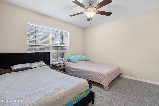 bedroom with carpet floors, ceiling fan, and a textured ceiling