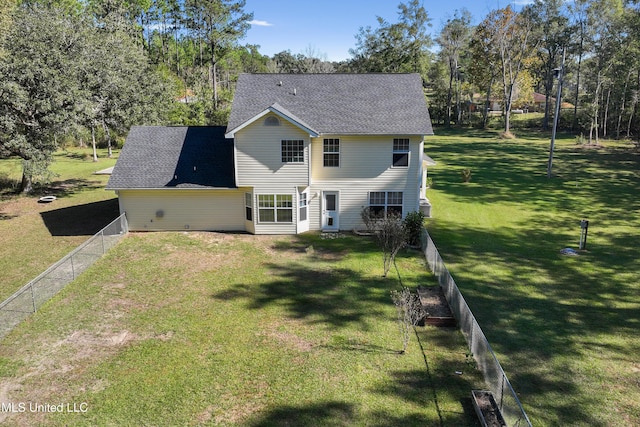 rear view of house featuring a lawn