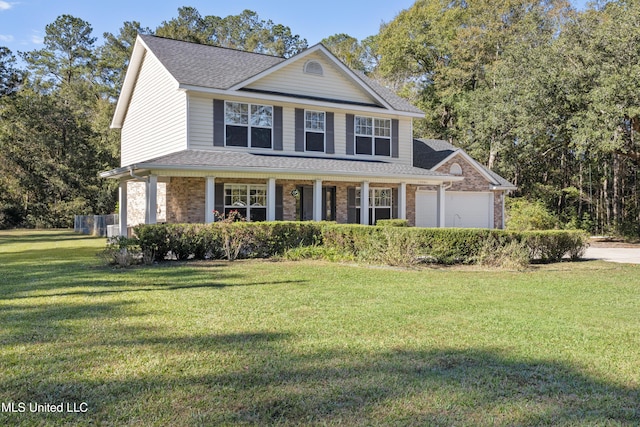 view of front of home featuring covered porch, a garage, and a front yard