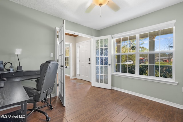 office area featuring a healthy amount of sunlight, ceiling fan, french doors, and hardwood / wood-style floors