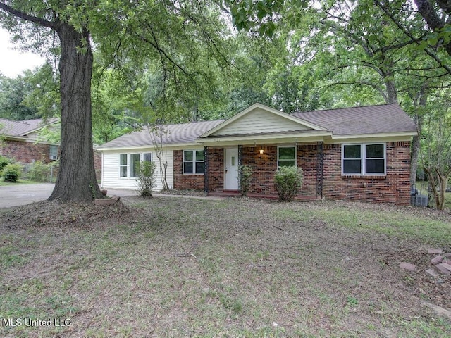 ranch-style home featuring brick siding, covered porch, and central AC