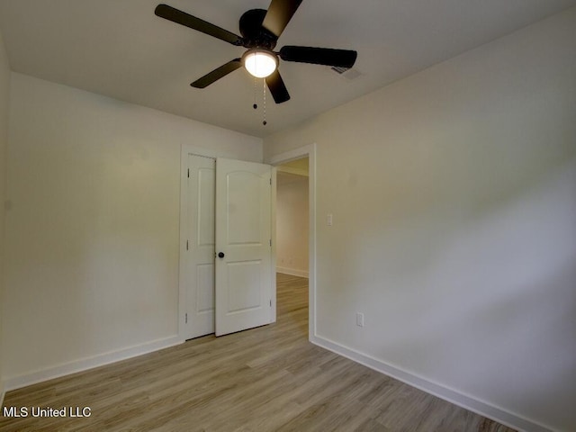 empty room featuring baseboards, light wood-style flooring, and a ceiling fan