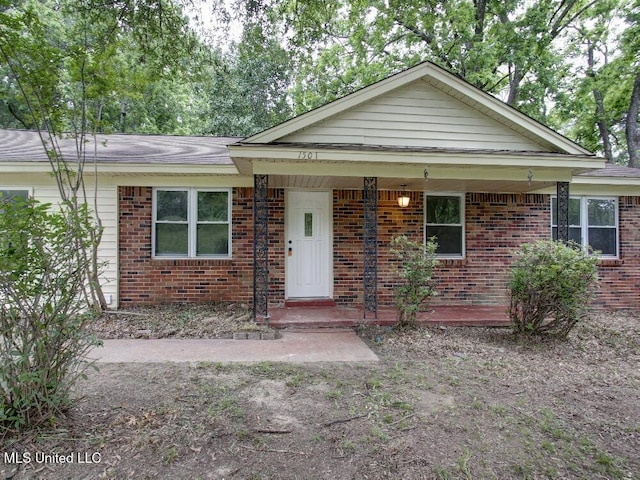 view of front facade featuring brick siding and a porch