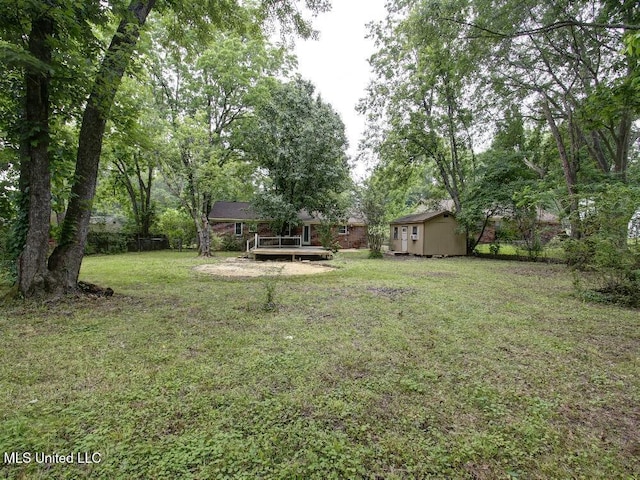 view of yard featuring a deck, an outdoor structure, and a storage shed