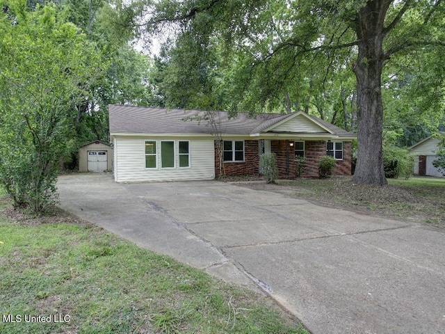 ranch-style home featuring driveway, an outbuilding, and a shed