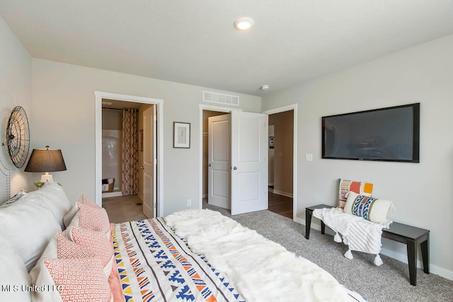 bedroom featuring connected bathroom and carpet