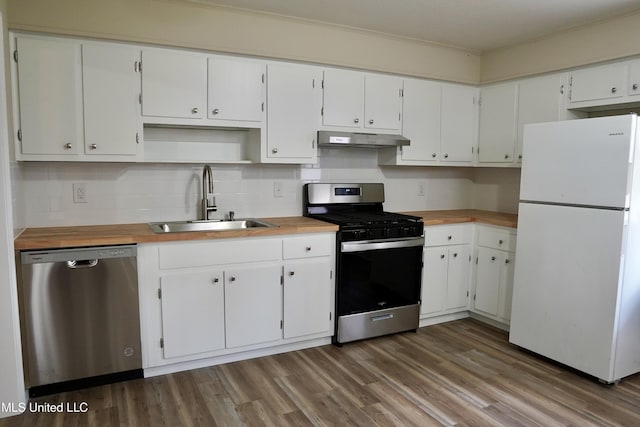 kitchen with stainless steel appliances, wood-type flooring, sink, and white cabinets