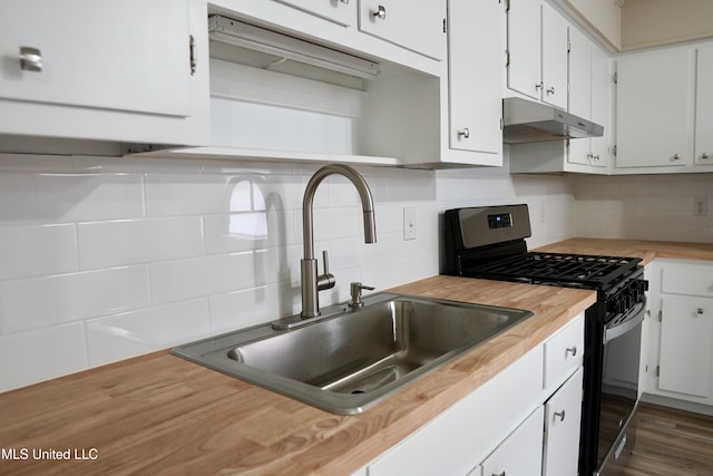 kitchen with dark hardwood / wood-style floors, white cabinetry, sink, decorative backsplash, and stainless steel gas range