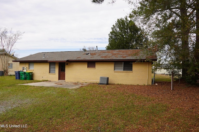 rear view of property featuring a lawn and a patio area