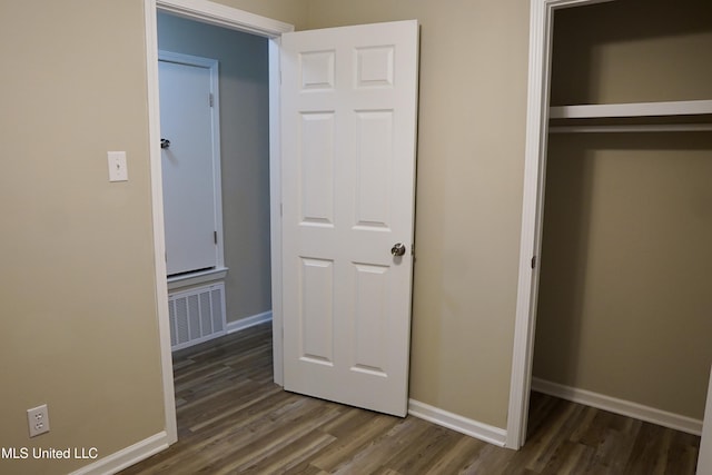 unfurnished bedroom featuring dark hardwood / wood-style flooring and a closet