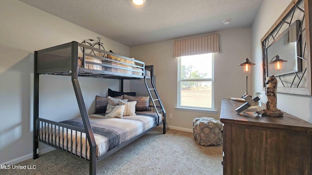 carpeted bedroom featuring baseboards and a textured ceiling