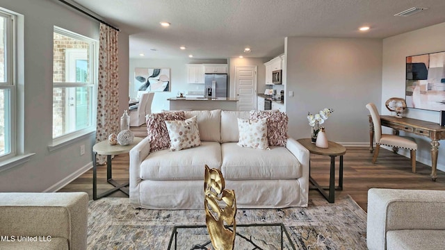 living area with baseboards, recessed lighting, wood finished floors, and visible vents