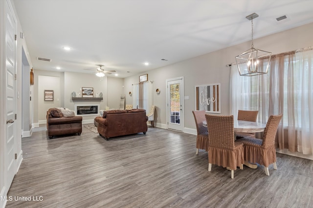 dining room with hardwood / wood-style flooring and ceiling fan with notable chandelier