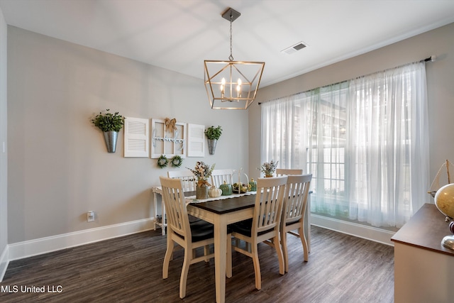 dining room with a healthy amount of sunlight, dark wood-type flooring, and a chandelier