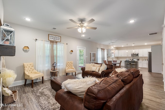 living room featuring ceiling fan and hardwood / wood-style floors