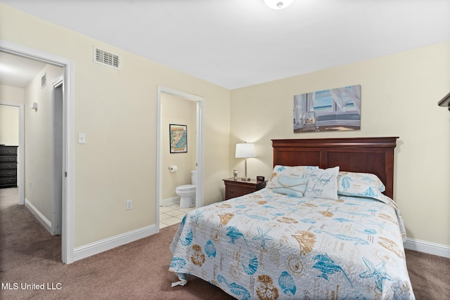 bedroom featuring connected bathroom and light colored carpet