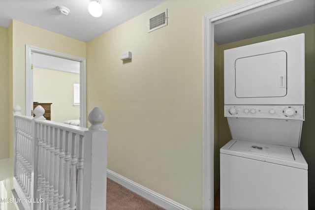 clothes washing area with carpet floors and stacked washer and clothes dryer