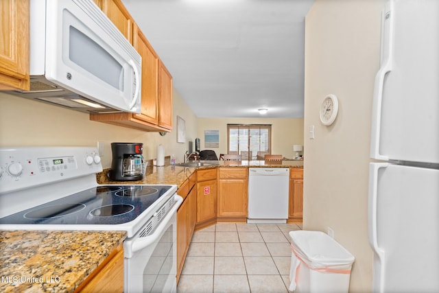 kitchen with light stone countertops, sink, kitchen peninsula, white appliances, and light tile patterned flooring