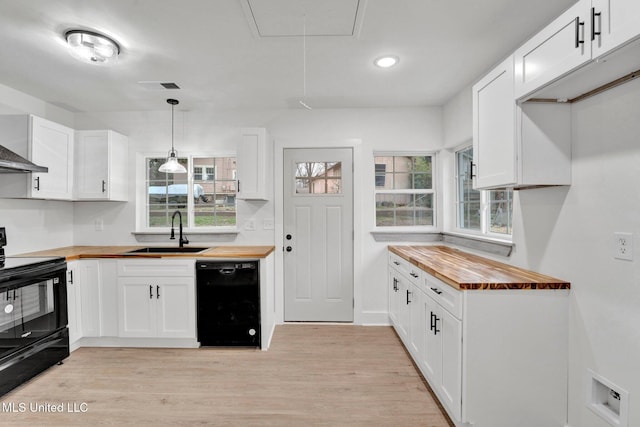 kitchen with black appliances, a sink, white cabinetry, light wood finished floors, and wooden counters