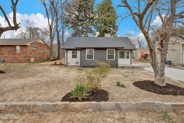 view of front of house featuring brick siding and roof with shingles