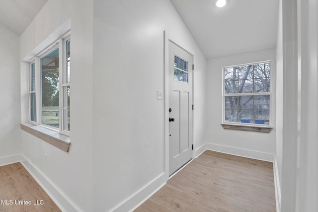 entryway with baseboards, lofted ceiling, and wood finished floors