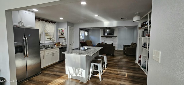 kitchen with light stone counters, stainless steel refrigerator with ice dispenser, white cabinets, black electric cooktop, and dark wood-style flooring