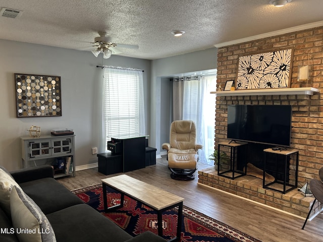 living room featuring a ceiling fan, wood finished floors, visible vents, and baseboards