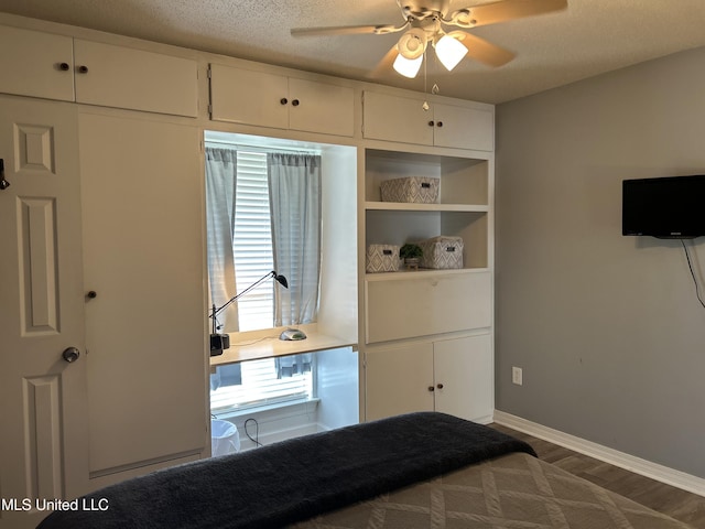 bedroom featuring a ceiling fan, dark wood finished floors, a textured ceiling, and baseboards