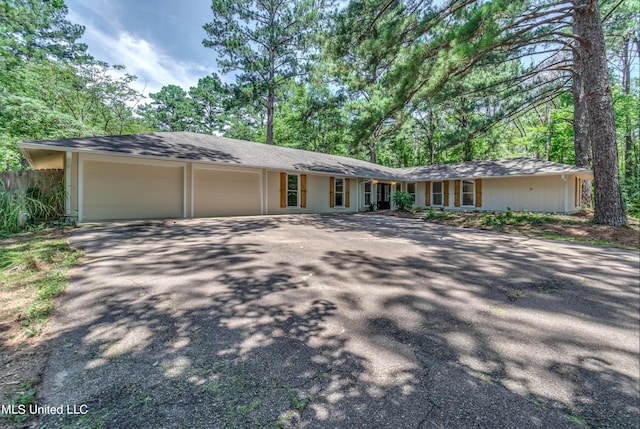 551 Holly Bush Rd, Brandon, MS 39047 - ranch-style home with asphalt driveway, an attached garage, fence, and roof with shingles