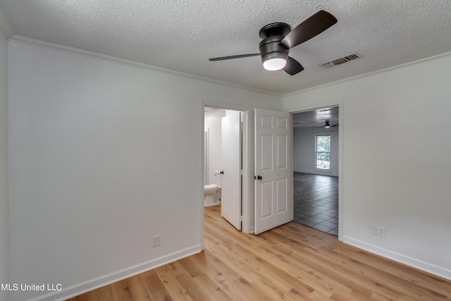 551 Holly Bush Rd, Brandon, MS 39047 - unfurnished bedroom with ornamental molding, light wood-type flooring, a textured ceiling, baseboards, and ensuite bath