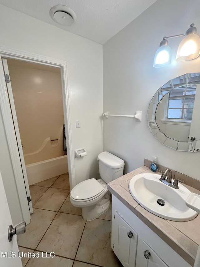 bathroom featuring tile patterned floors, vanity, a textured ceiling, and toilet