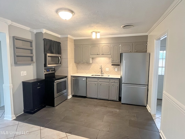 kitchen with sink, ornamental molding, and stainless steel appliances