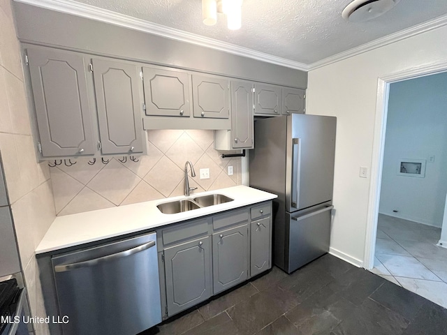 kitchen featuring appliances with stainless steel finishes, backsplash, crown molding, sink, and gray cabinets