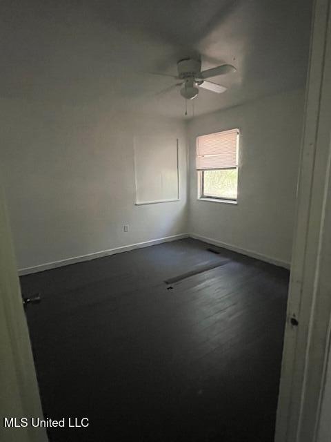 unfurnished room with ceiling fan and baseboards