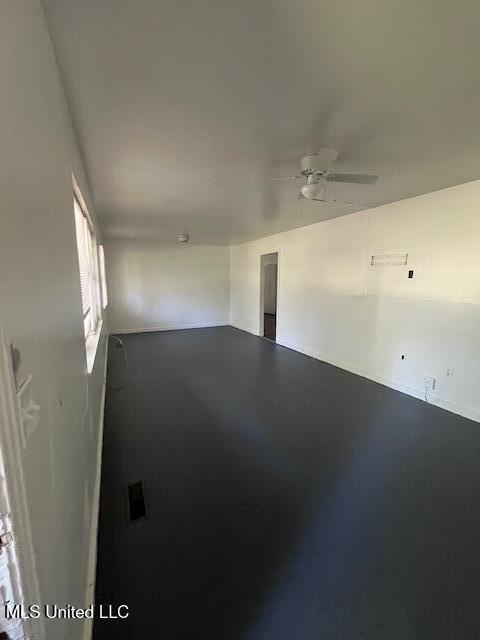 spare room featuring finished concrete floors and ceiling fan