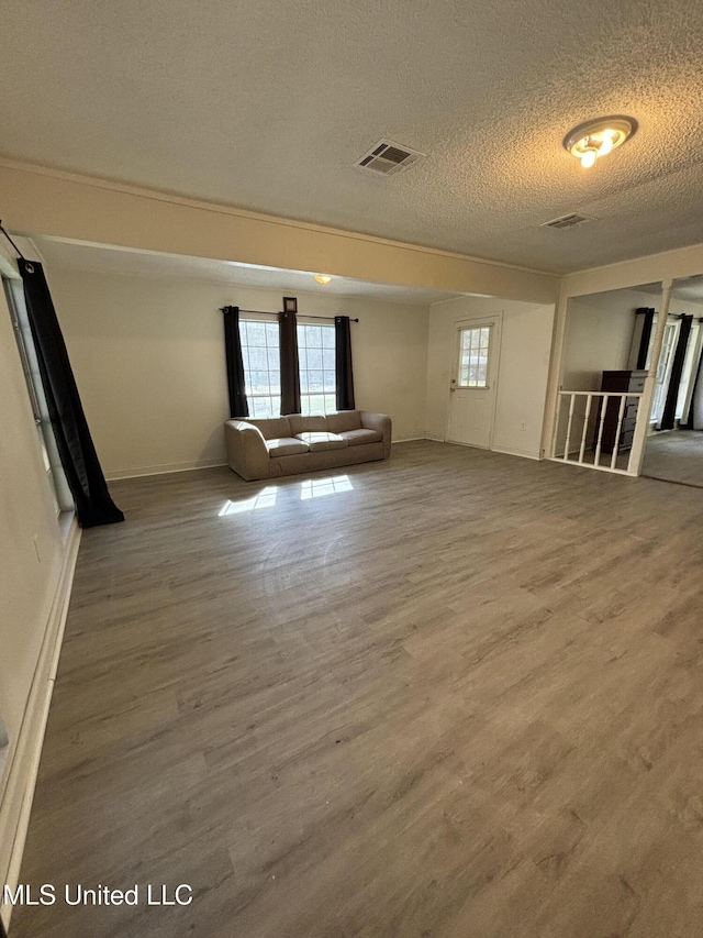 empty room with wood-type flooring and a textured ceiling