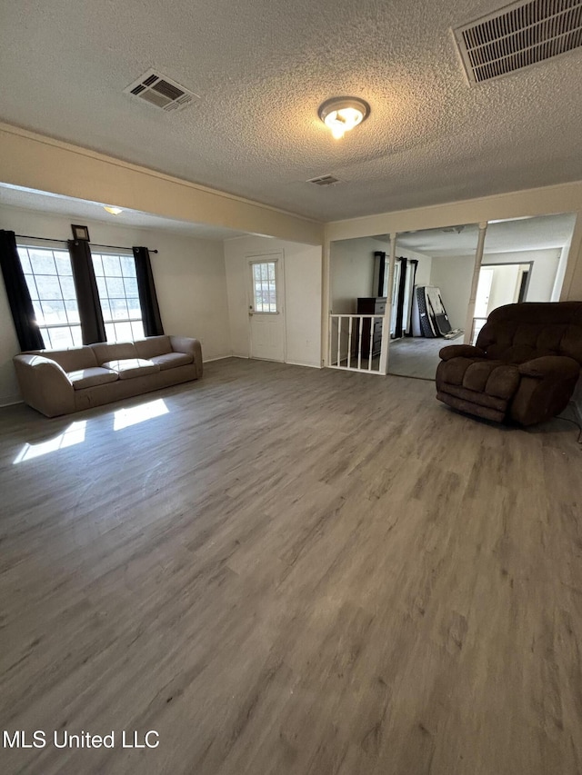 unfurnished living room with hardwood / wood-style floors and a textured ceiling