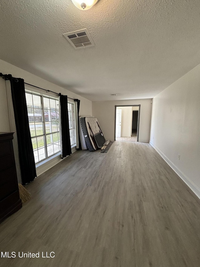 unfurnished room with wood-type flooring and a textured ceiling