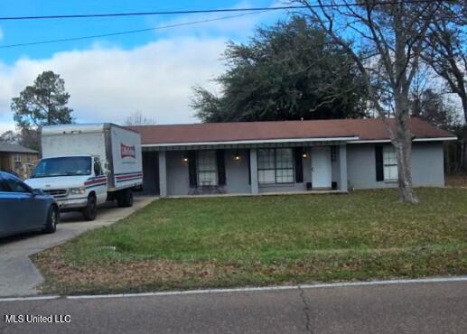 ranch-style home featuring driveway and a front lawn