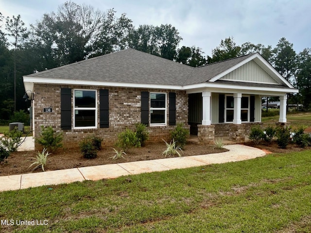 32 Crown Dr, Lucedale, MS 39452 - view of front of home featuring roof with shingles, a front lawn, brick siding, and covered porch