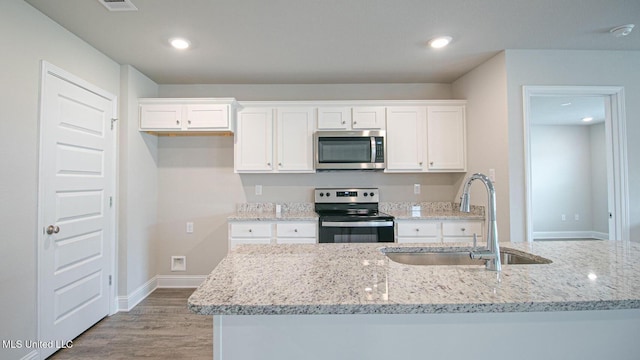 32 Crown Dr, Lucedale, MS 39452 - kitchen featuring stainless steel appliances, white cabinetry, wood finished floors, light stone countertops, and recessed lighting