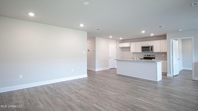 32 Crown Dr, Lucedale, MS 39452 - kitchen with appliances with stainless steel finishes, light wood-type flooring, white cabinetry, a kitchen island with sink, and recessed lighting