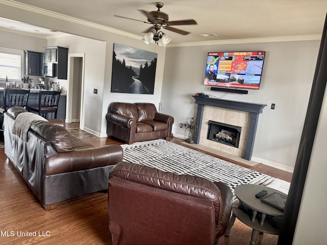 4896 Park N Dr, Olive Branch, MS 38654 - living room with ceiling fan, ornamental molding, wood finished floors, a tiled fireplace, and baseboards