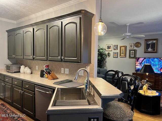 kitchen with sink, a textured ceiling, ceiling fan, tasteful backsplash, and stainless steel dishwasher